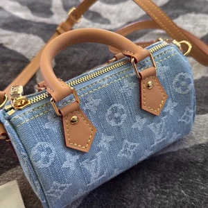 Louis vuitton speedy nano i jeans - Superfin mini axelväska från Louis Vuitton i ljusblått jeansmaterial med klassiskt monogrammönster. Väskan har detaljer i beige skinn, guldfärgade metalldelar och dragkedja. Speedy nano heter modellen , säljer pga flytt
