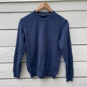 Blå rundhalsad tröja från Sand - Mörkblå rundhalsad tröja från Sand Copenhagen. Tröjan har lång ärm och är tillverkad i ett mjukt material som känns skönt mot huden. Perfekt för lager-på-lager och enkel att matcha med olika outfits.