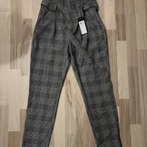 Rutiga högmidjade byxor  - Strl Xs. Rutiga kostymbyxor från Vero Moda med hög midja helt nya! Innersöm mått 74cm  Nypris 400