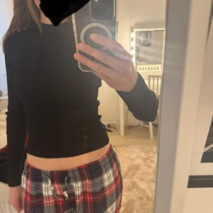 Svart polotröja - Säljer en svart polotröja med tight passform. Tröjan har långa ärmar och en hög krage, perfekt att styla till olika outfits. Enkel och stilren design som passar till mycket.