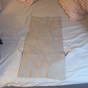Beige ribbad långkjol - Säljer en beige ribbad långkjol med hög midja. Kjolen är stickad och har en rak passform som sitter snyggt på kroppen. Nytt skick, aldrig använd , ställ frågor om de behövs 💕