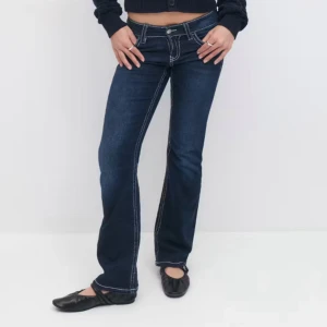 Lågmidjade bootcut jeans - Snygga mörkblå jeans med bootcut passform och markerade vita sömmar. Byxorna har låg midja, klassiska fickor och dragkedja framtill. Perfekta för en trendig och avslappnad look. Köpt på Gina Young i storlek 170 för 360 kr (mycket bra skick, knappt använda) 
