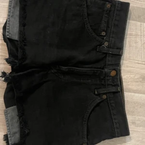 Svarta jeansshorts från Levi's - Säljer ett par svarta jeansshorts från Levi's. Shortsen är låg midjade och i bra skick.