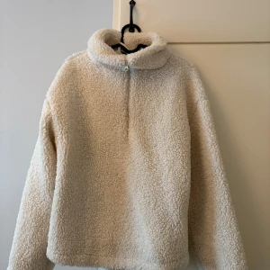 Beige fleece-tröja/jacka med halv dragkedja - Mysig beige fleece-tröja med hög krage och halv dragkedja framtill. Perfekt för kyliga dagar och enkel att matcha med olika outfits. Långärmad och fluffig för extra komfort. Xs men passar s