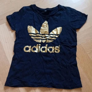 Adidas t-shirt - Säljer denna Adidas tröja då den inte kommer till användning, har använts några gånger men är i jättebra skick, ser ut att vara lite sliten men det är bara för att den är dåligt vikt i garderoben så det går att stryka. Vet tyvärr inte storlek men jag har storlek XS/S och den passar jättebra.