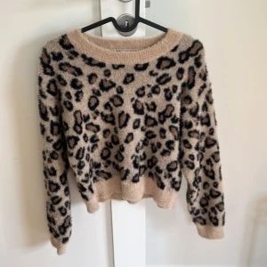 Beige leopardmönstrad fluffig tröja från Lindex - Supermjuk och fluffig beige tröja från Lindex med leopardmönster i svart och brunt. Tröjan har lång ärm och rund halsringning, säljer för att den inte är min storlek!🫶🏼