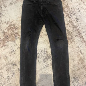 Svarta Levis 519 jeans - Säljer ett par svarta Levis 519 jeans med smal passform. Klassisk femficksmodell med Levis-röd etikett på bakfickan och svart läderpatch i midjan. Perfekta för dig som gillar en skinny stil och vill ha ett par stilrena jeans.