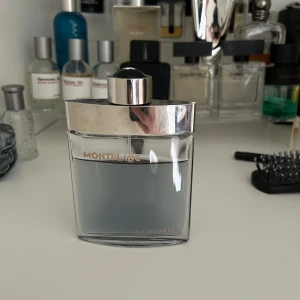Montblanc Individuel Eau de Toilette - Montblanc Individuel är en elegant parfym med en fräsch och kryddig doftprofil. Flaskan är rektangulär med rundade kanter, genomskinlig med silverfärgat lock och detaljer. Doften har inslag av sötma, frukt, aromatiska och varma kryddor samt träiga och pudriga toner. Box fås med