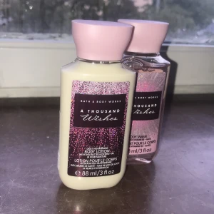 Bath & Body Works A Thousand Wishes set - Set med body lotion och body wash från Bath & Body Works i doften A Thousand Wishes. Båda flaskorna är 88 ml och har rosa lock och glittriga etiketter. Lotionen är krämig och vit, duschkrämen är ljusrosa och genomskinlig. Perfekt storlek för resan eller gymväskan.