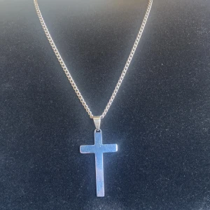 Silver kors halsband - Ett kors halsband i nytt skick, kedjan är inte i riktigt silver men är gjord av stål, 60cm lång, 75kr