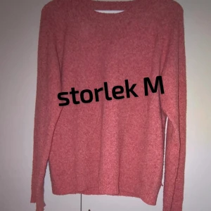 Rosa stickad tröja i storlek M - Mysig rosa stickad tröja med rund hals och långa ärmar. Perfekt för kyliga dagar och enkel att matcha med jeans eller kjol. Tröjan har en avslappnad passform och ribbade muddar vid ärmslut och nederkant.