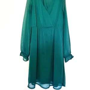 Grön omlottklänning med v-ringning - Snygg grön omlottklänning med v-ringning och långa, transparenta ärmar med volangdetalj vid ärmslut.