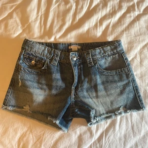 Jeansshorts från Gina Tricot - Snygga blå jeansshorts från Gina Tricot young, med lite slit och knappar på fickorna. Typ helt nya, och nästan inte alls använda