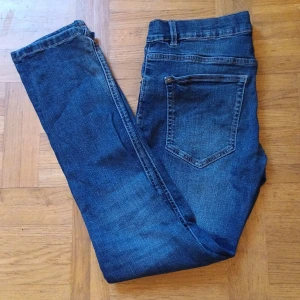 Blå jeans från LAB Industries - Snygga blå jeans från LAB Industries med klassisk femficksdesign och bruna sömmar. Jeansen har normal passform och raka ben, tillverkade i mjukt denimtyg som sitter skönt hela dagen. Perfekta för dig som gillar en enkel och stilren look. Hör av er med frågor eller snabb affär. Pris kan diskuteras 