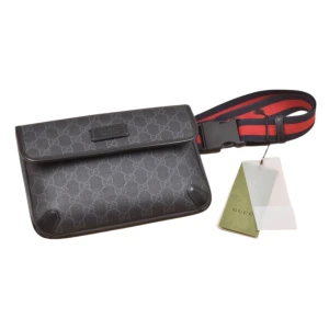 Svart axelväska från G med monogram - Snygg svart axelväska   med klassiskt GG-monogram över hela väskan. Väskan har ett lock med magnetstängning och en bred, justerbar axelrem i rött och marinblått. Perfekt för att bära det viktigaste med stil.    Beställnings vara!