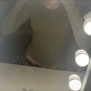 Olivgrön långärmad tröja - Säljer en olivgrön långärmad tröja med tight passform. Tröjan är enkel och stilren, perfekt att matcha med jeans eller kjol. Materialet känns mjukt och följsamt mot kroppen. En basic som funkar till många olika looks.