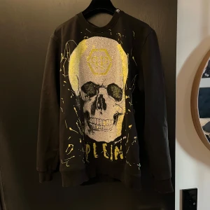 Philipp Plein sweatshirt  - Svart sweatshirt från Philipp Plein med en neongrön dödskalle. Den är storlek L men sitter mer som M. Har använts några gånger med är fortfarande fräsch. Hör av er om ni har frågor.