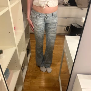 Ljusblå bootcut jeans med slitningar - Säljer ett par ljusblå lågmidjade jeans med slitningar framtill! Så snygga! Skriv för fler bilder😇