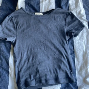 Blå basic t-shirt från Gina Tricot - En enkel blå t-shirt från Gina Tricot, basically basics-kollektionen. Modellen är kortärmad med rund halsringning och har en klassisk, rak passform. Har använts fåtal gånger. Säljer då jag inte får användning av den.