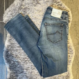Jacob Cohën Jeans Mörblåa - Exklusiva och stilrena jeans från Jacob Cohën, modell Type 622 C, i mörkblå tvätt, storlek W31. Jeansen är i väldigt fint skick, endast sparsamt använda. Enda anmärkningen är att läderlappen bak har lossnat lite i ena kanten (se bild) – inget som påverkar användning eller helhetsintryck.