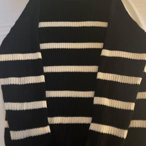 Svartvit randig stickad tröja - Snygg stickad tröja med breda svarta och vita ränder. Tröjan har en klassisk, avslappnad passform och är perfekt för dig som gillar en stilren look. Ribbstickad struktur och långärmad modell gör den både bekväm och trendig. Perfekt för vardagsbruk och till många tillfällen. Går inte att gå fel med denna!! Tveka inte att höra av dig vid frågor:)