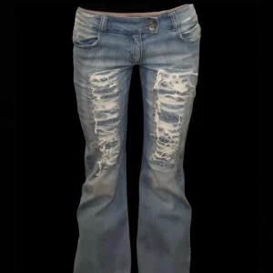 Blå bootcut jeans med slitningar - Sjukt snygga lågmidjade bootcut jeans!!  Midjemått: 41 cm  Midjehöjd: 19 cm  Innerbenslängd: 82 cm 