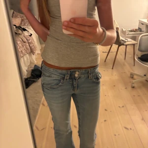 Ljusblå lågmidjade jeans strl 158/164  - Säljer ett par ljusblå jeans från Gina young strl 158/164, i modell med låg midja och bootcut. Jeansen har klassiska fickor fram och bak! har även sprättat upp dom där nere så de blivit längre! 