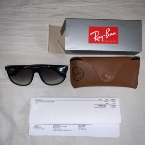 Svarta Ray-Ban Boyfriend solglasögon - Snygga svarta Ray-Ban Boyfriend RB4147 solglasögon med klassisk, lite större rektangulär form. Glasen är mörktonade och bågarna är i blank svart plast. Kommer med originalfodral och box. Perfekta för att lyfta din stil i solen.