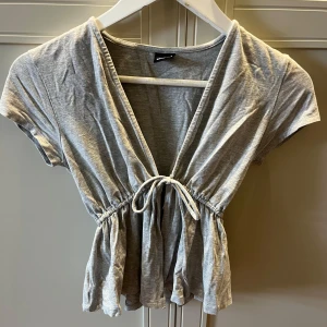 Grå topp med snörning - En jätte söt topp från Gintricot i storlek S. Bara använd en gång, bra skick. 