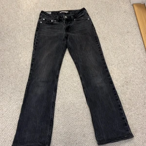 Levi's Premium svarta bootcut jeans - Svarta Levi's Premium jeans i modellen Low Pitch Boot med klassisk femficksdesign och bootcut-ben. Jeansen har låg midja och är tillverkade i slitstarkt denim med snygg tvättad finish. Perfekta för dig som gillar en avslappnad men ändå stilren look.