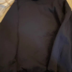 Mörkblå hoodiejacka från Polo Ralph Lauren - Mörkblå hoodiejacka från Polo Ralph Lauren med dragkedja framtill och klassisk logga på bröstet. Jackan har huva och långa ärmar, perfekt för en chill och stilren look. Tillverkad i mjukt material som känns skönt mot huden.