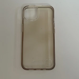 Genomskinligt mobilskal Iphone 13 - Ett genomskinligt mobilskal som passar Iphone 13. Köpt på Flying tiger för 50kr men jag säljer för endast 10kr. Den har blivit lite missfärgad så den har en lite gul/brun underton (som man kan se på bilderna), det är dock inget som påverkar funktionen! Den är gjord av återvunnen plast och har ett litet märke nere i högra hörnet där det står det (se bild 2). Superfint att ha bara som det är men passar också perfekt till att lägga in bilder, klistermärken eller annat skoj!