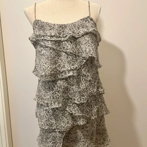 Söt volangklänning från Mango - Supersöt volangklänning från Mango! Sparsamt använd, fint skick! Storlek S. I blomstermönster, färg: grå