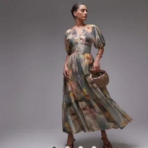 Blommig långklänning från other stories med puffärm - Drömmig långklänning med blommigt mönster i pastelliga toner av beige, gul, rosa och blå. Klänningen har v-ringning, puffiga korta ärmar och markerad midja. Tillverkad i ett tunt, flowy material som ger en romantisk vibe. Perfekt för sommarens alla tillfällen. Nyskick, inga anmärkningar förutom bortklippt storlekslapp. Är stl 38, normal storlek men kan även passa 36:a. Skickar bilder med mått om önskas.