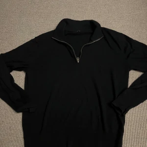 Marin blå quarter zip tröja från Uniqlo XS - Marinblå långärmad tröja från Uniqlo i storlek XS. Tröjan har en hög krage med quarter zip-dragkedja och är tillverkad i ett mjukt stickat material. Enkel och clean design som funkar till många olika stilar.