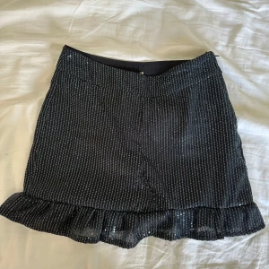 Svart glittrig minikjol med volang - 🦋Handsydd🦋Supersnygg svart minikjol i paljetttyg med volangkant längst ner. 