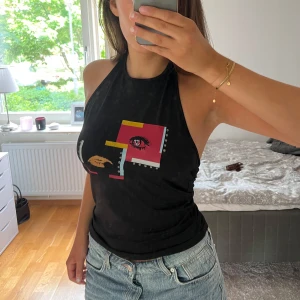 Svart halternecktopp med tryck - Jätte snygg svart halternecktopp köpt från Humana som aldrig kommit till användning🖤finns ingen lapp så vet inte märket🖤har en ”secondhand lukt” fast jag har tvättat tröjan 3 gånger, därav det billiga priset🖤passar xs-m🖤 hör av dig vid frågor!!