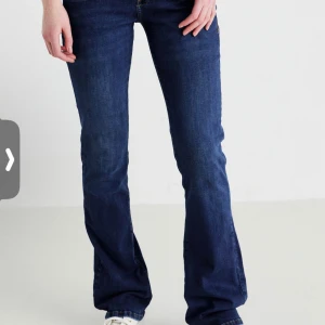 Mörkblå ltb bootcut jeans - Snygga mörkblå jeans med bootcut passform och klassisk femficksdesign. Jeansen har låg midja och är tillverkade i ett stretchigt denimtyg som sitter skönt. Perfekta för dig som gillar en retroinspirerad look med utsvängda ben.