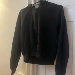 Svart hoodie med half zip från KappAhl - Svart zip hoodie, från Kappahl, lite kortare vid magen. Aldrig använd.