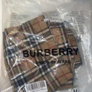Rutig Burberry shorts i bomull - Snygga shorts från Burberry i klassiskt beige, svart, vit och röd rutigt mönster. De har elastisk midja för skön passform och är tillverkade i mjuk bomull. Perfekta för en trendig och avslappnad look. Dem är rätt små och skulle säga att dem passar S eller Xs. Hör av er vid minsta lilla fundering 🌺💴🥂✅❤️