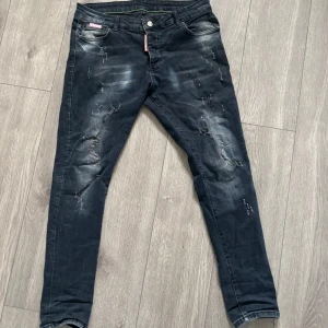 Dsquared2 jeans - Snygga svarta skinny jeans från Dsquared2 med slitna detaljer och coola blekta partier. Klassisk femficksmodell med Dsquared2-logga på röd etikett vid gylfen. Jeansen har en smal passform och är tillverkade i bomull med stretch.