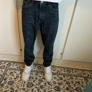 Mörkblå jeans från Zara, loose fit - Säljer ett par mörkblå jeans från Zara i loose fit med klassisk femficksdesign och raka ben. Jeansen har normal midja och är tillverkade i bomull. Perfekta för en avslappnad och trendig look.