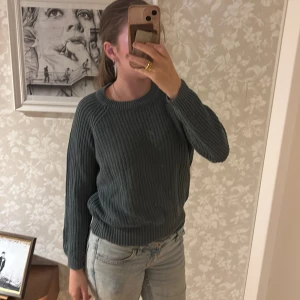 Grön stickad tröja lager 157 - Säljer en grön stickad tröja från The Black Label Collection i storlek M. Tröjan har en klassisk rund halsringning, ribbade muddar och långärmad passform. Perfekt för lager-på-lager och chill dagar.