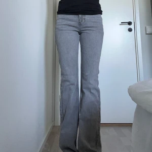 Grå bootcut jeans från Gina Tricot stl 34 - Grå jeans från Gina Tricot, bootcut och medelhög midja. Aningens slitna längst ner, men annars som nya. Storlek 34