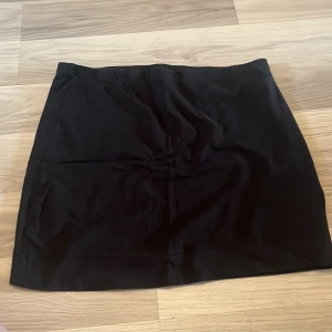 Två enkla kjolar i svart och grått - Säljer två basic kjolar, en helsvart och en grå med tunna ränder. Båda är korta och raka i modellen, perfekta till sneakers eller boots. Sköna och stretchiga, passar till många olika stilar. Blå/xs/X grå/s/m