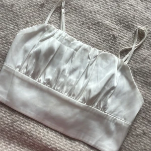 Vit satin bandeau topp med tunna band - Supersnygg vit bandeau topp i satin med tunna justerbara axelband. 