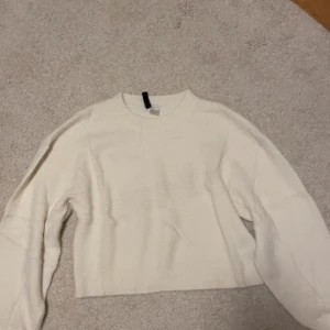Vit stickad tröja från H&M - Säljer en stilren vit stickad tröja från H&M. Den är i storlek M men är liten i storleken. 