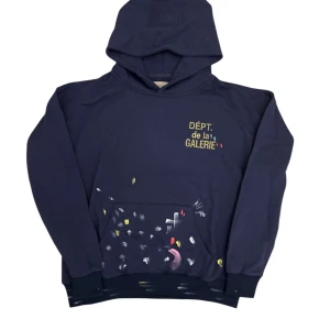  Dept de la Galerie-hoodie  - Säljer en cool mörkblå hoodie från Dept de la Galerie med färgglada detaljer och text på bröstet. Tröjan har en rymlig passform och en stor ficka framtill. Perfekt för en avslappnad stil.mvh scandicfashion 
