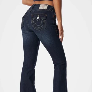Mörkblå jeans med broderade fickor - Snygga mörkblå jeans från True Religion som heter Becca mid rise boot cut flap och har broderade detaljer på bakfickorna. Säljer då jag inte har så stor användning för dem. De är i mycket bra skick, de är hela och har inga fläckar. Betalade 1299 för dem i nyskick. Hör av dig om du är intresserad eller har några frågor!