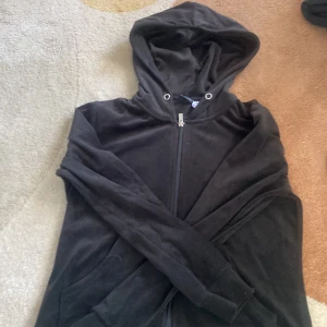 Svart hoodie från Gina Tricot - Säljer en svart hoodie från Gina Tricot med dragkedja och huva. Perfekt för en avslappnad stil. Den har långa ärmar och är gjord i ett mjukt material.